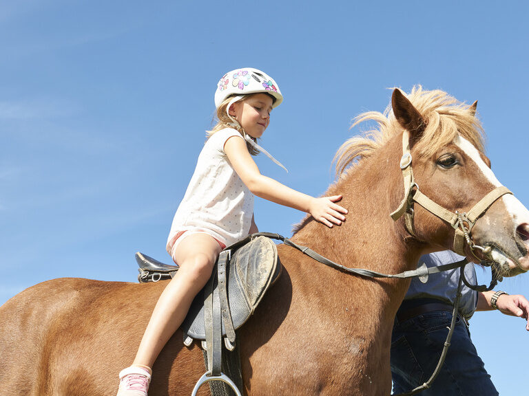 Kind reitet auf Pony
